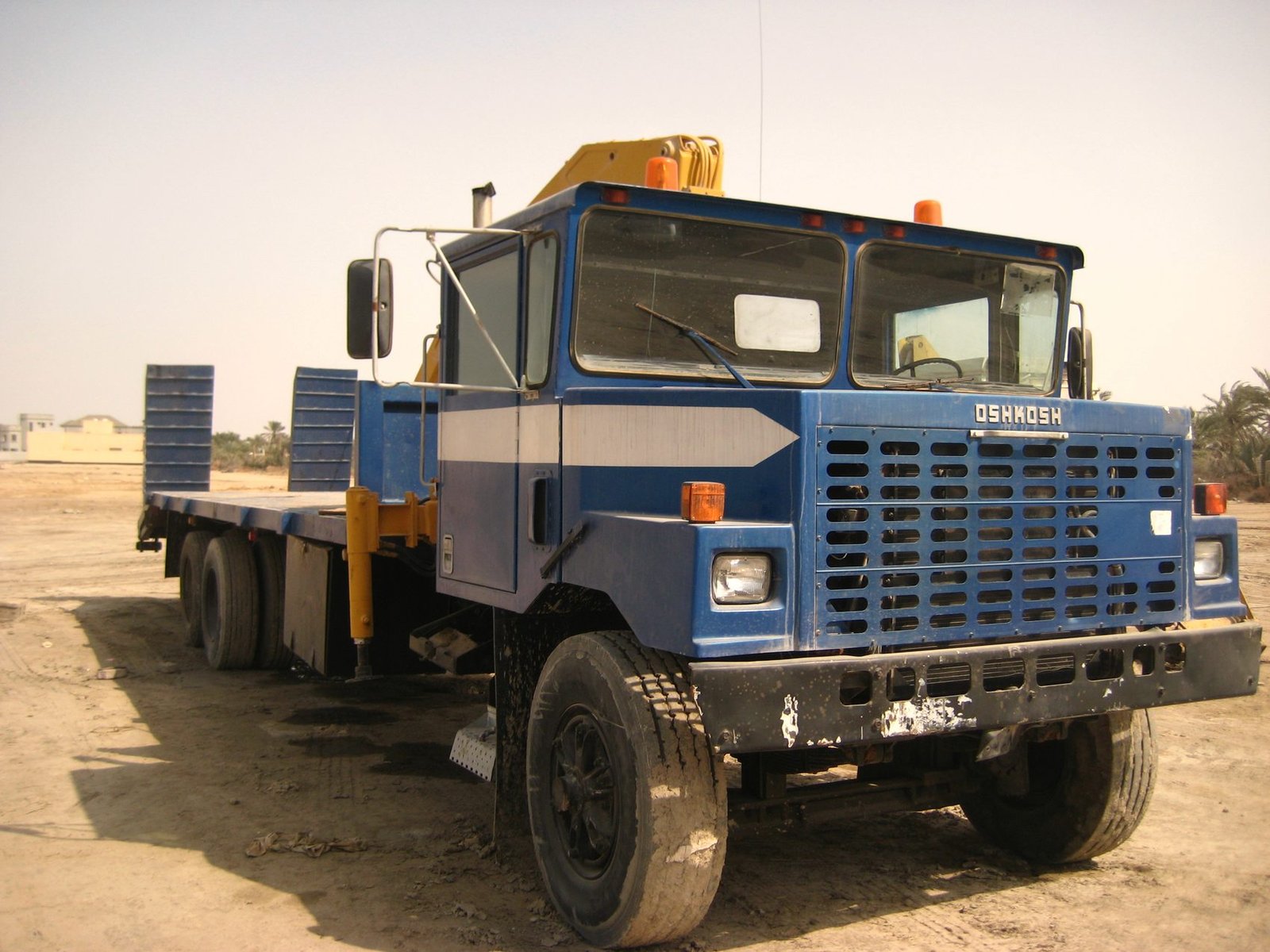 Oilfield flatbed truck parked on a gravel yard