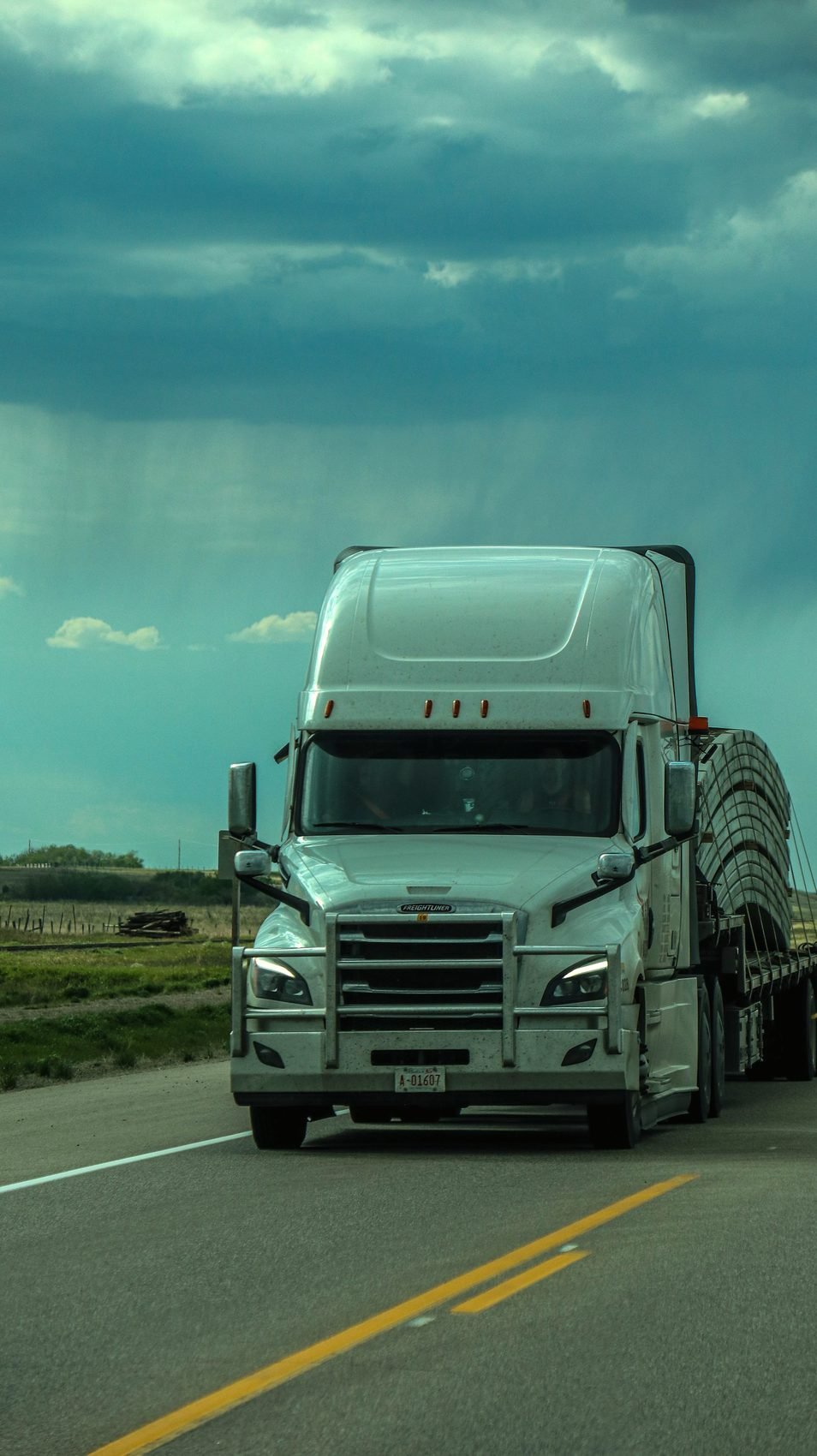 Tractor unit head-on on an empty road at dusk
